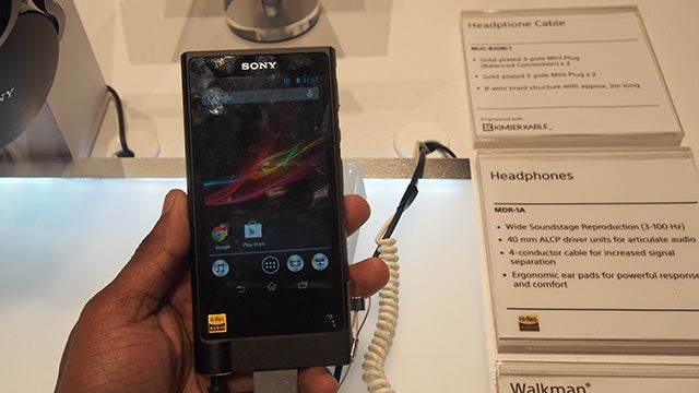 Hand holding Sony NWZ-ZX2 Walkman on display at electronics store.