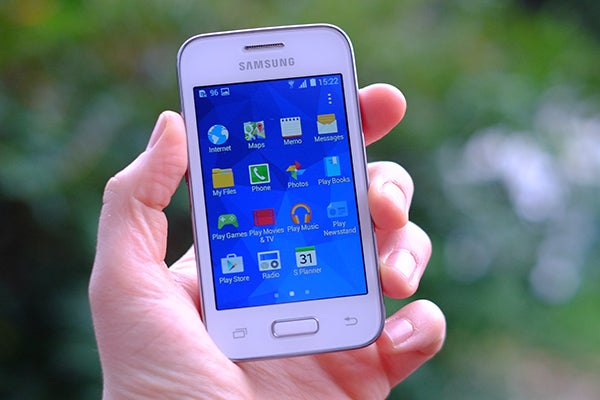 Hand holding a Samsung Galaxy Young 2 smartphone displaying apps.