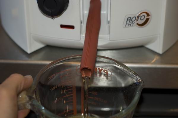 Measuring oil in front of DeLonghi RotoFry F28311 deep fryer.