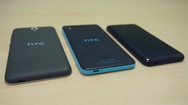 Three HTC Desire 620 smartphones in black, blue, and dark blue colors.Three HTC Desire 620 smartphones displayed on a table.