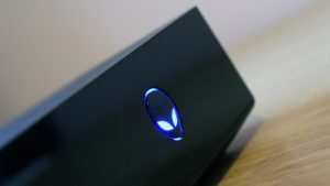 Close-up of Alienware Alpha with illuminated logo.
