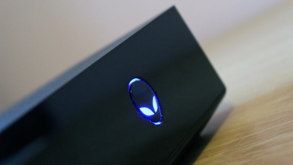 Close-up of Alienware Alpha with illuminated logo.