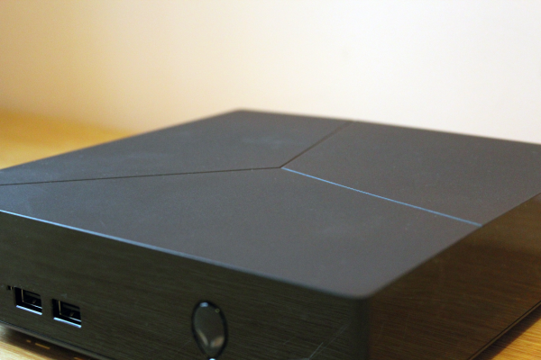 Close-up of an Alienware Alpha gaming console on a desk.