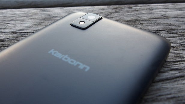 Close-up of a Karbonn smartphone camera on wooden background.