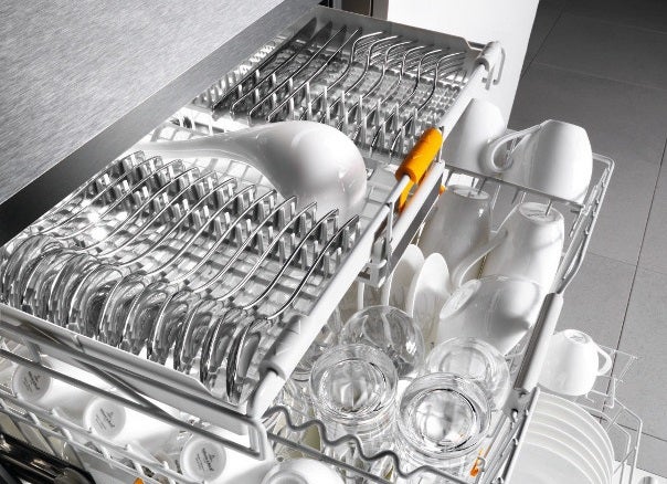 Miele G6410SC dishwasher loaded with clean dishes and utensils.