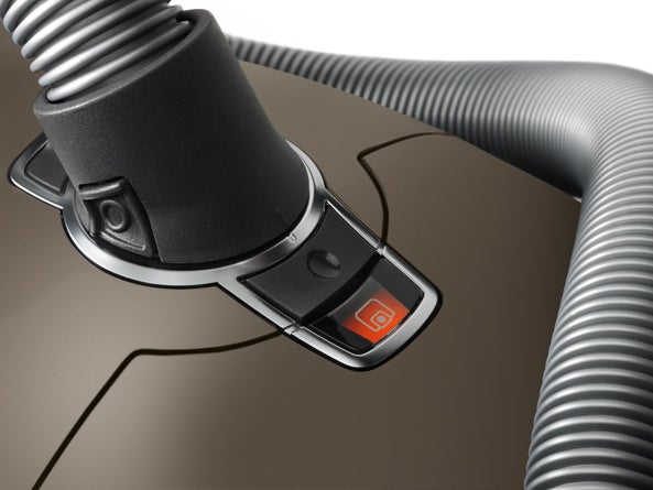 Close-up of Miele vacuum cleaner hose connection and power control.