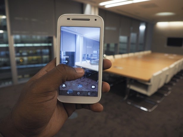Hand holding a smartphone taking a picture of a conference room.