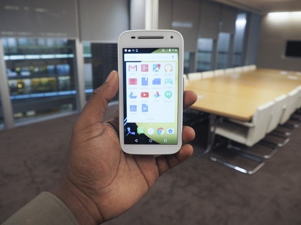 Hand holding Motorola Moto E 2nd Generation in an office setting.