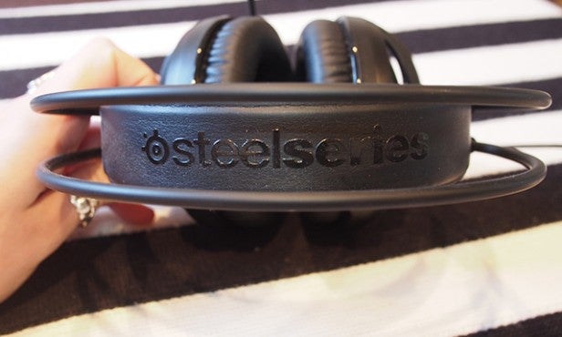 Hand holding SteelSeries Siberia V3 gaming headset.