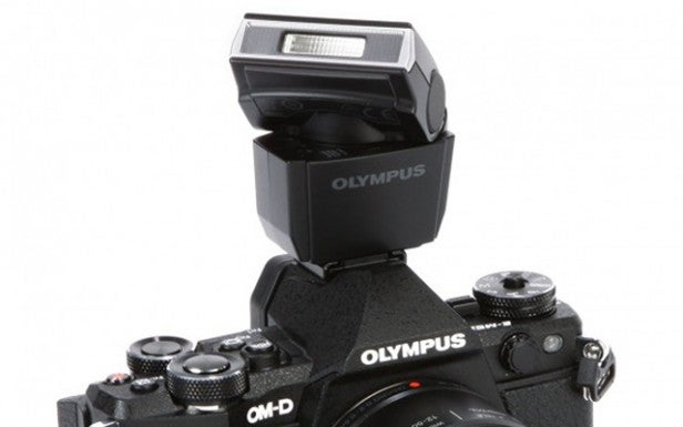 Olympus camera with external flash attached.