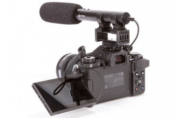Professional video camera with external microphone and flip-out screen.