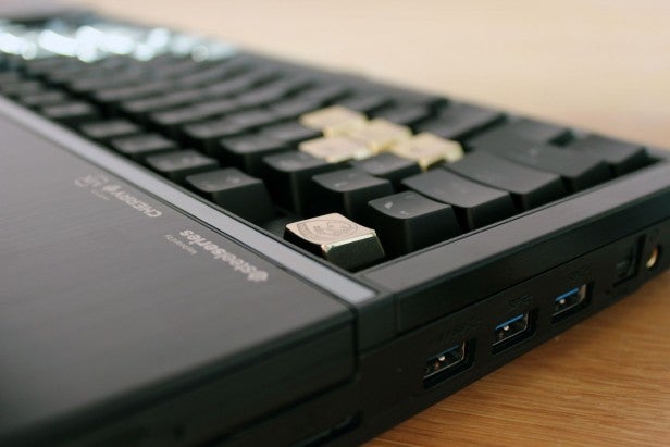 Close-up of mechanical keyboard with USB ports and raised key.