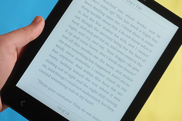 Hand holding a Cybook Ocean e-reader displaying a page of text.
