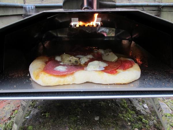 Pizza baking inside Uuni 2 pizza oven.