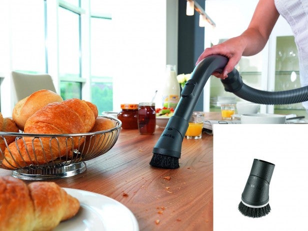 Person using Miele vacuum to clean crumbs off table