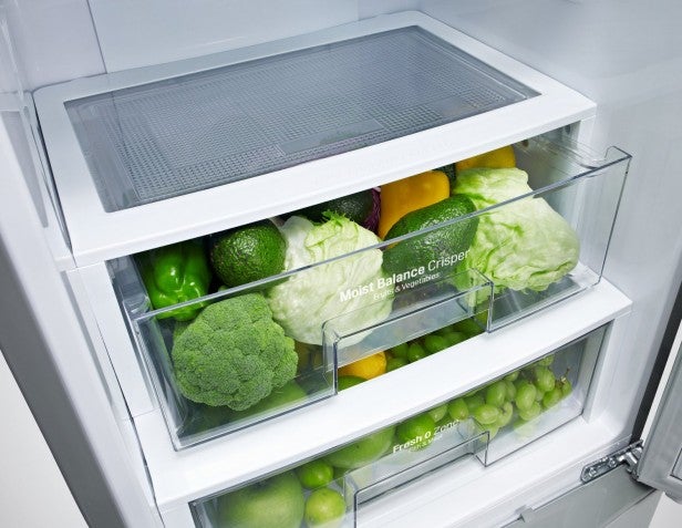 LG fridge freezer filled with fresh vegetables in crisper drawer.
