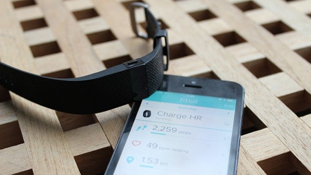 Fitbit Charge HR with smartphone showing health data.