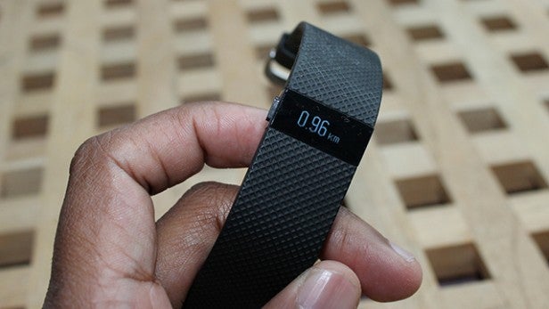 Hand holding Fitbit Charge HR showing distance tracked