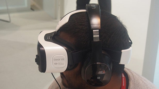 Person wearing Samsung Gear VR headset with headphonesPerson wearing Samsung Gear VR headset and headphones.Person using Samsung Gear VR headset with headphones