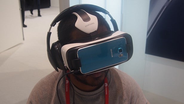 Person wearing Samsung Gear VR headset with Galaxy S6.Person using Samsung Gear VR with headphones and lanyard.