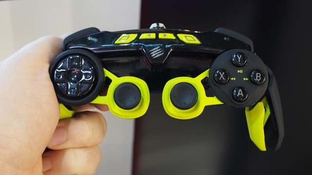 Hand holding a black and yellow Mad Catz L.Y.N.X. 3 controller