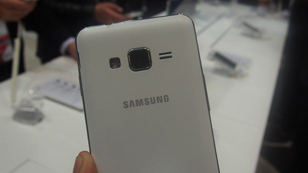 Hand holding Samsung Z1 smartphone at an event.Close-up of a white Samsung Z1 smartphone rear camera.
