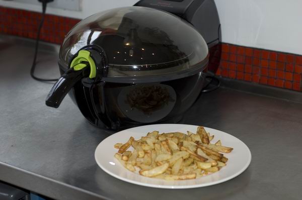 Tefal ActiFry Express XL air fryer with cooked fries on plate.