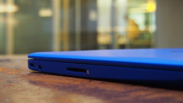 Close-up of blue laptop's connectivity ports on wooden surface