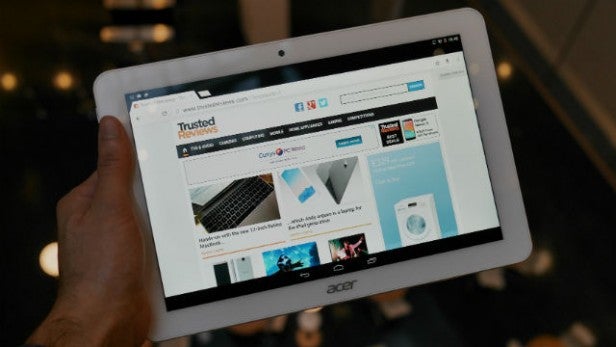 Hand holding a tablet displaying product review website.