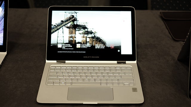 HP Spectre x360 laptop on a desk displaying a screen image.