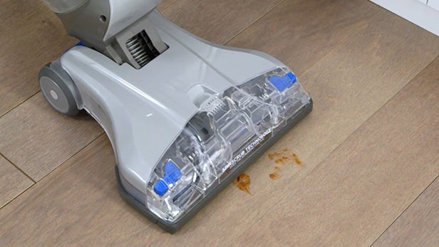 Vax Floormate Cordless cleaner being used on a dirty floor.
