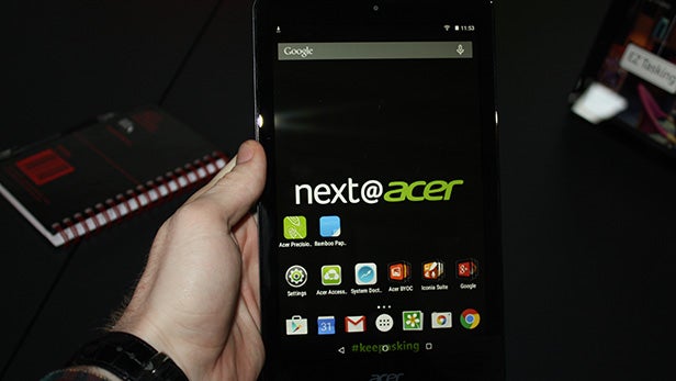 Hand holding Acer Iconia One 8 tablet displaying apps.