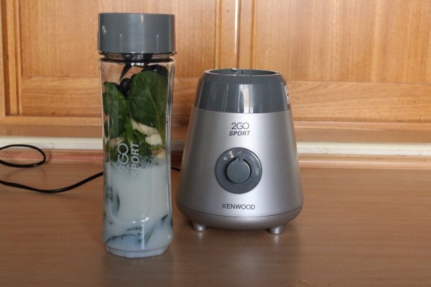 Kenwood 2Go Sport blender with spinach smoothie on a table.