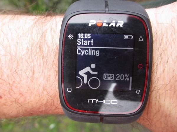Polar M400 watch on wrist displaying cycling start screen with GPS signal.