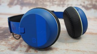 Blue Skullcandy Grind wireless headphones on wooden surface.