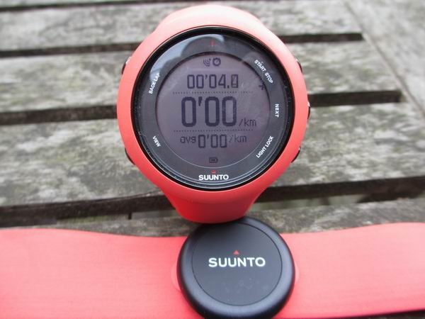 Suunto Ambit3 Sport watch on red strap with display visible.
