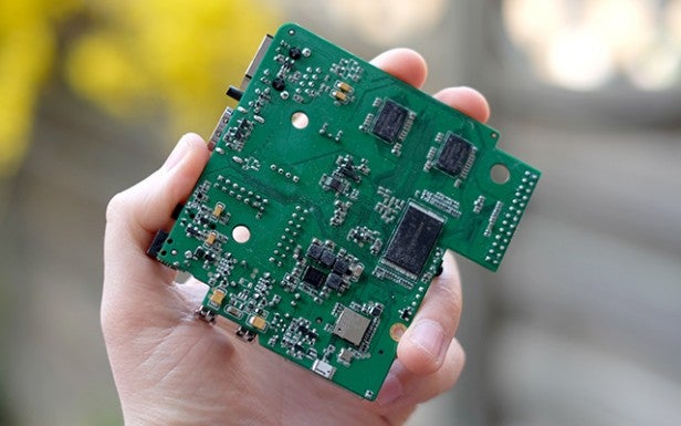 Hand holding a green Android motherboard.