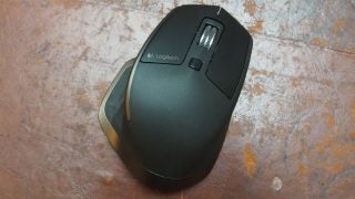 Logitech MX Master wireless mouse on a rustic surface.