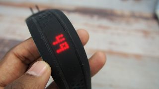 Hand holding Mio Fuse showing heart rate display