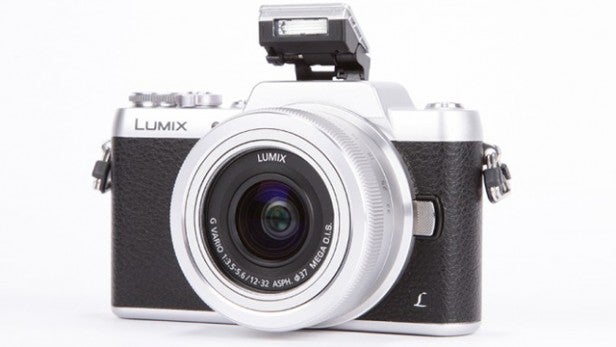 Lumix camera with pop-up flash extended on white background.