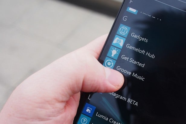 lumia950 9Hand holding a smartphone showing a list of apps on screen.