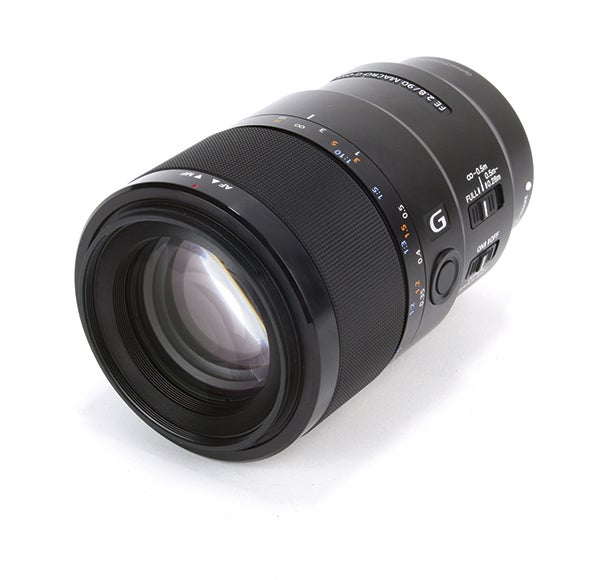 A black Sony 90mm camera lens kept on white background