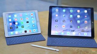 Two 9.7-inch iPad Pros with keyboards and stylus on table.