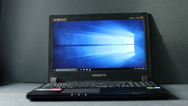 Gigabyte P35X v6 25Laptop on desk displaying screen with Windows desktop, keyboard visible.