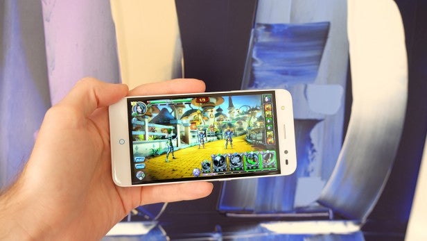 zte 7Hand holding smartphone displaying a game application