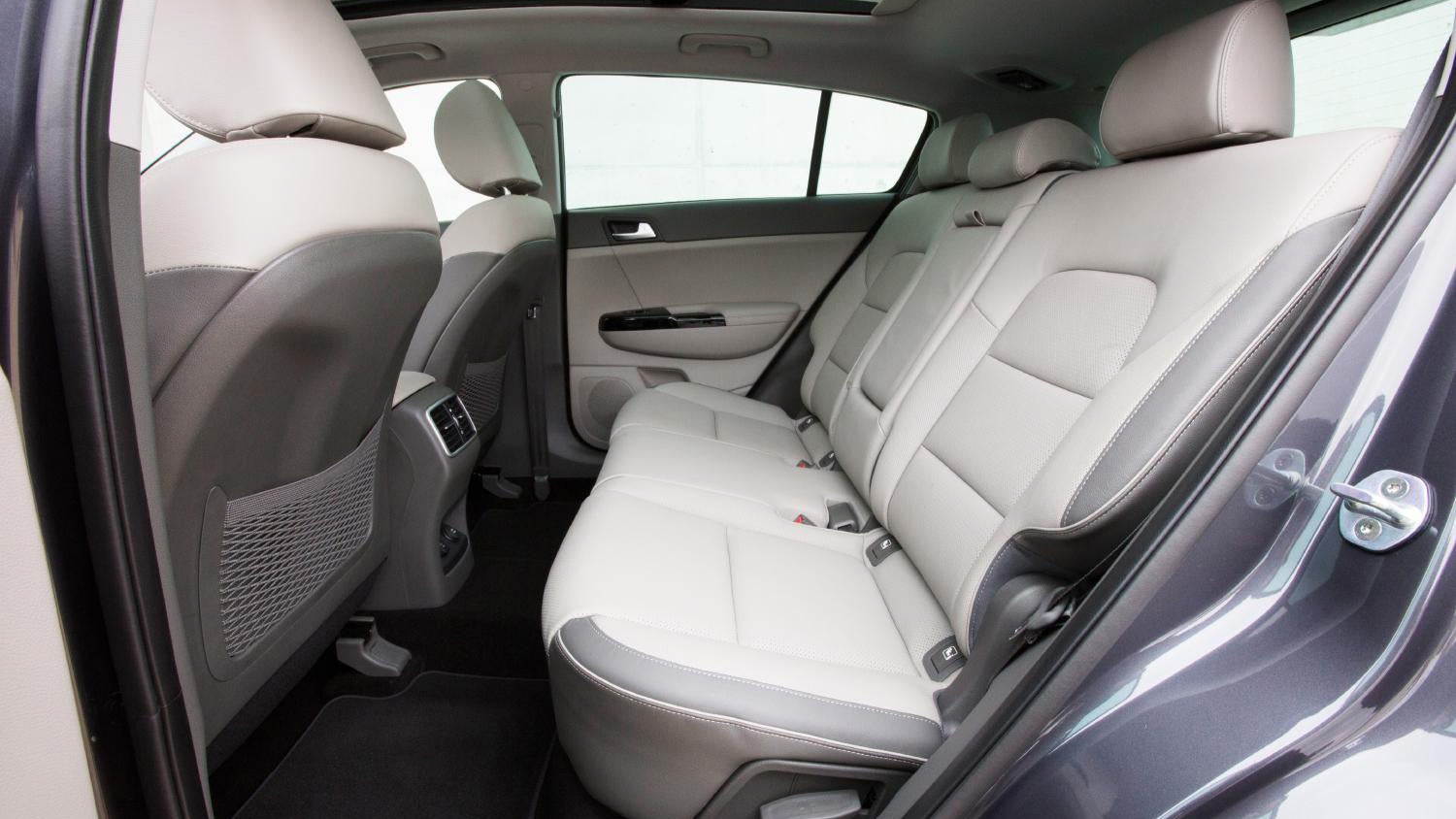 Interior view of Kia Sportage showing rear seats and door design.