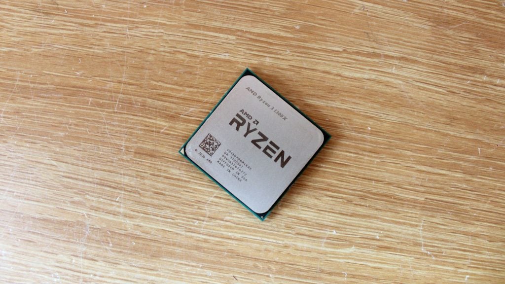 AMD Ryzen 3 1200X processor on a wooden surface.