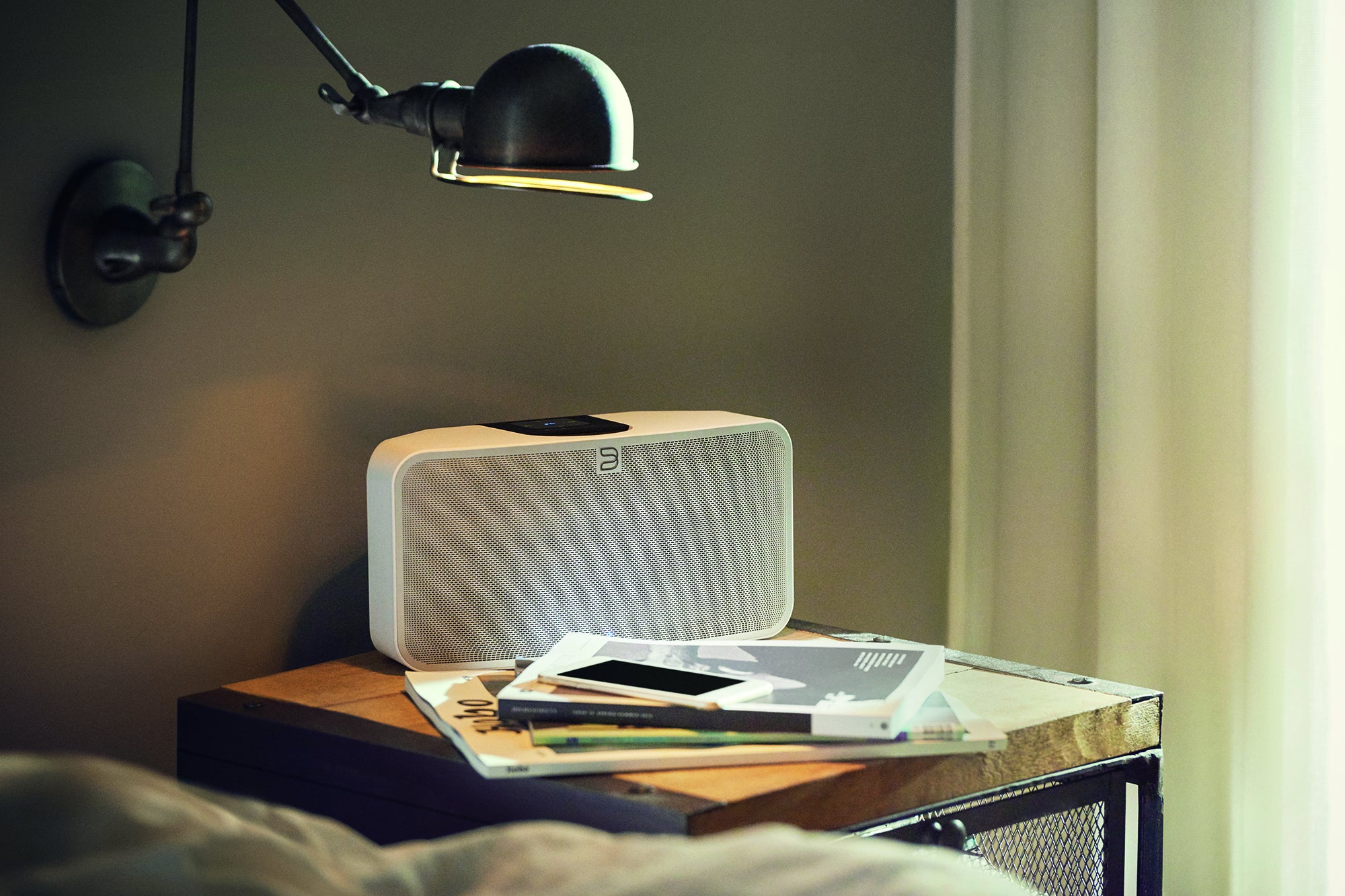 Bluesound Pulse Mini speaker on a bedside table