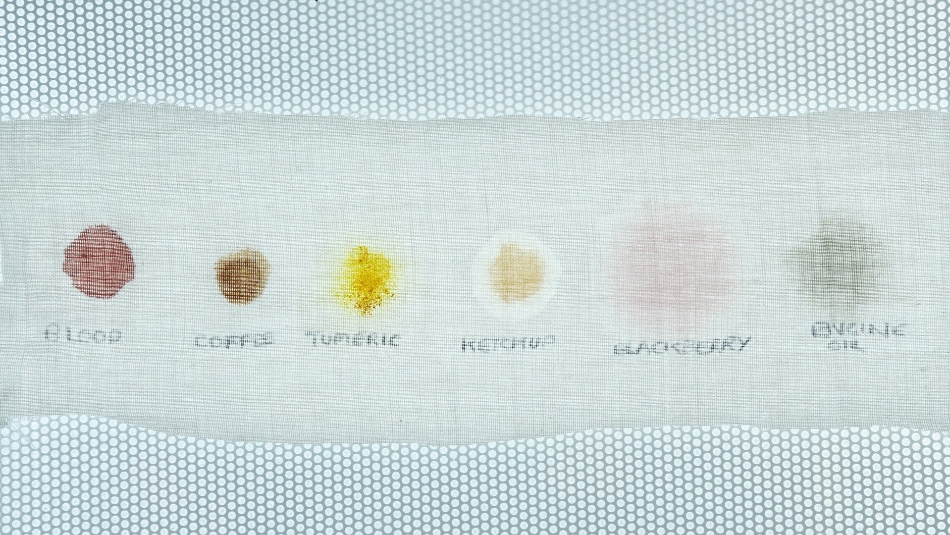Stain removal test swatches with labels on fabric.