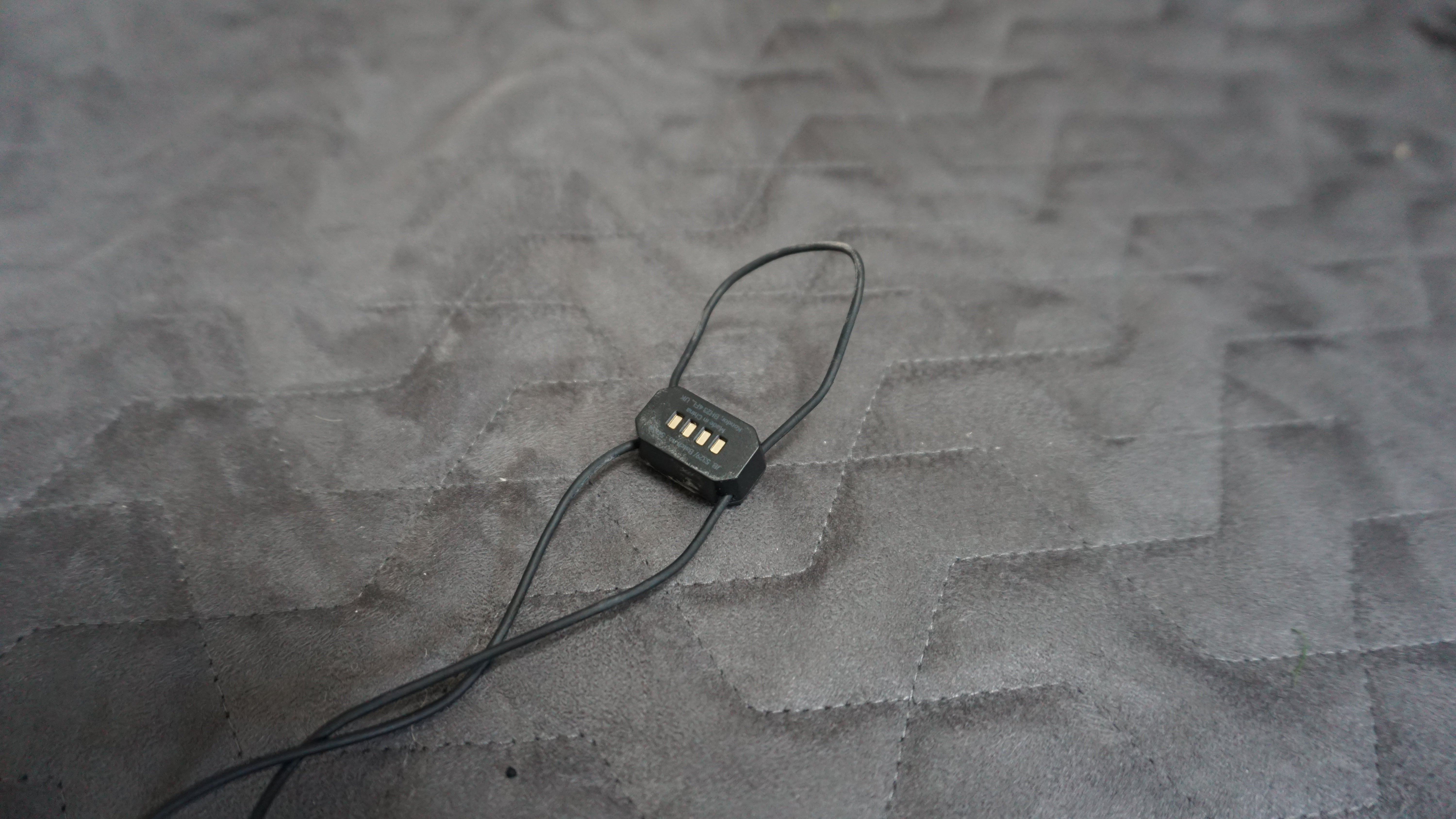 KitSound Immerse Active headphones charger on fabric surface.